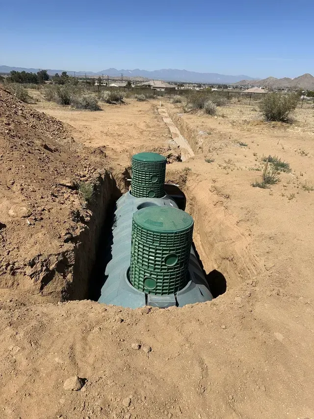 A septic tank is sitting in the middle of a dirt field.