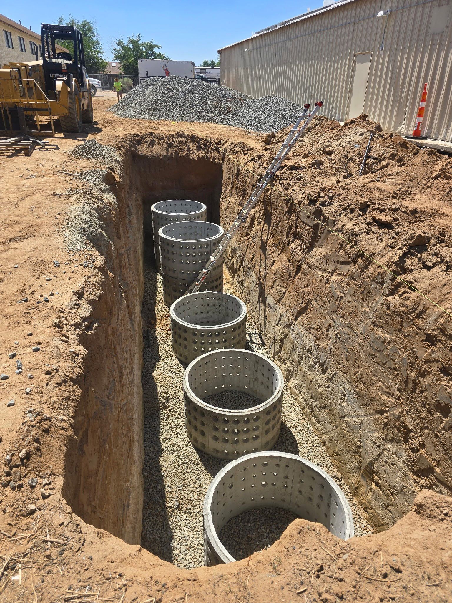 A row of concrete rings are sitting in a hole in the ground.