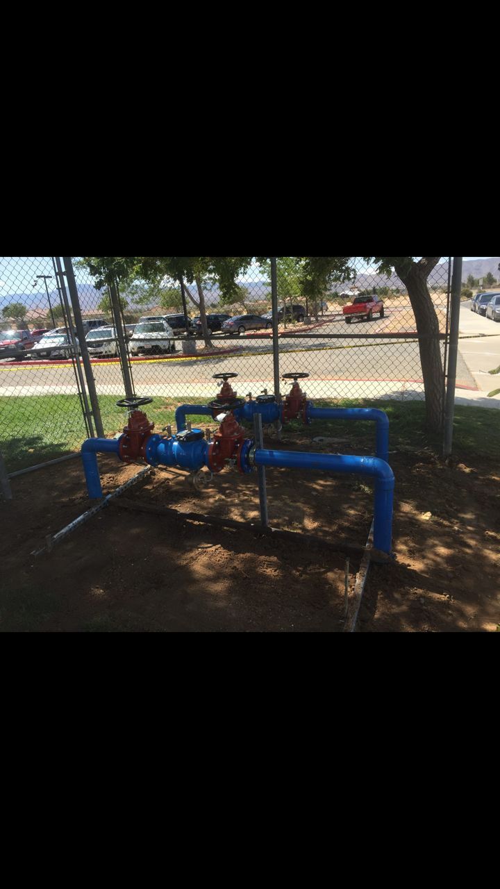 A bunch of blue pipes are sitting next to each other in a park.