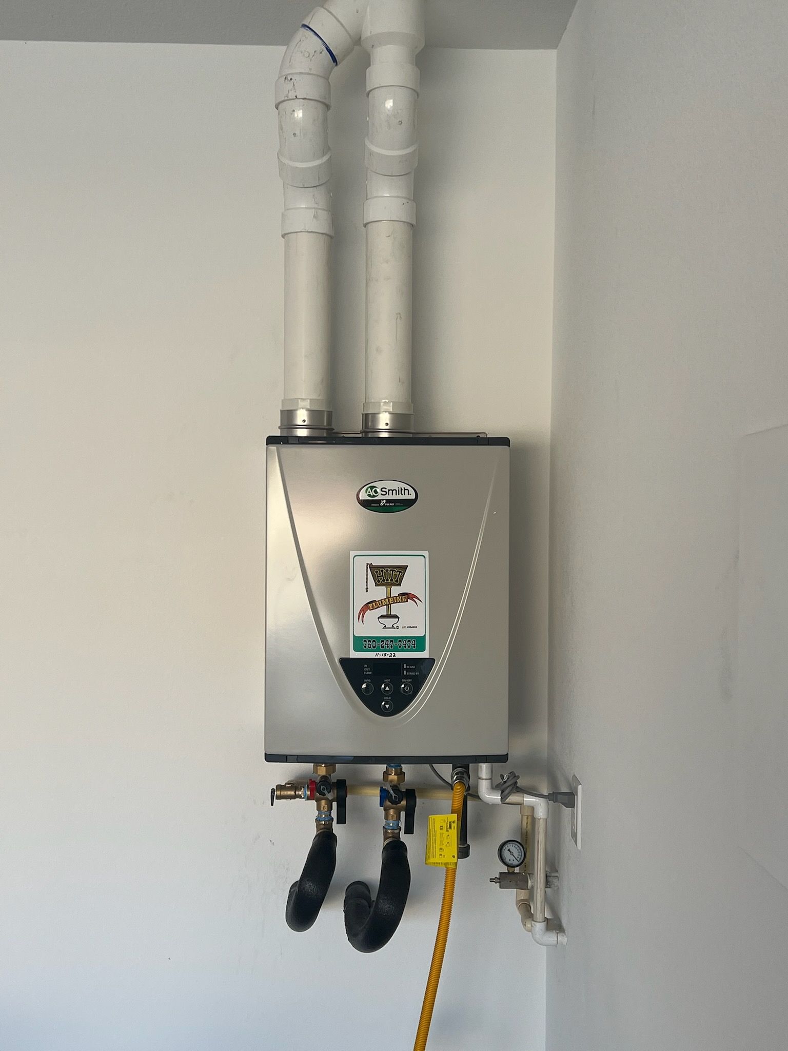 A water heater is mounted to a white wall