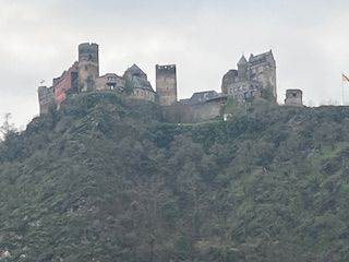 Castle perched atop a rocky hill, with several towers and buildings.