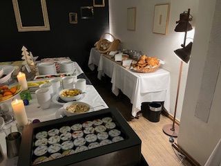 Buffet table with food and drinks in a brightly lit room.