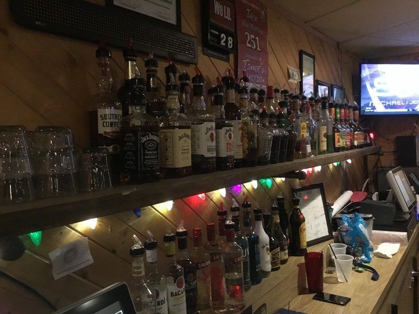 A bar with many bottles of liquor on shelves