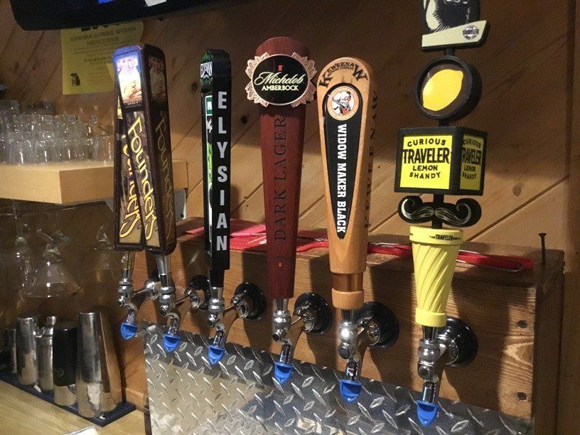 A row of beer taps with one that says traveler on it