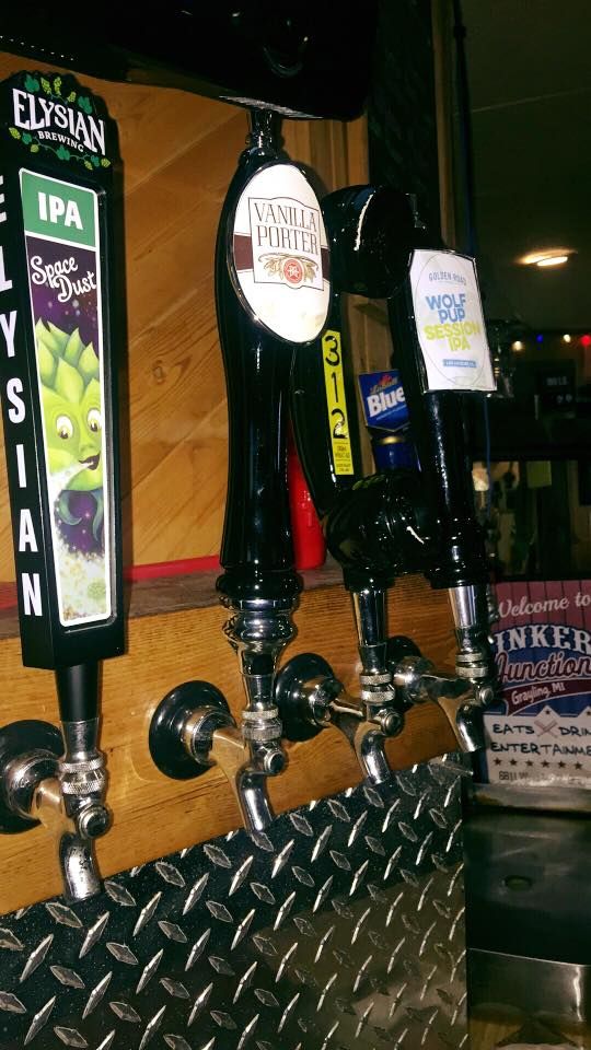 A row of beer taps are lined up on a counter.