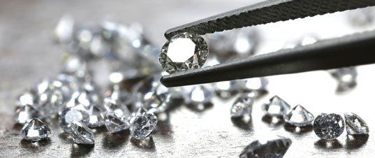 Brilliant cut diamond held by tweezers