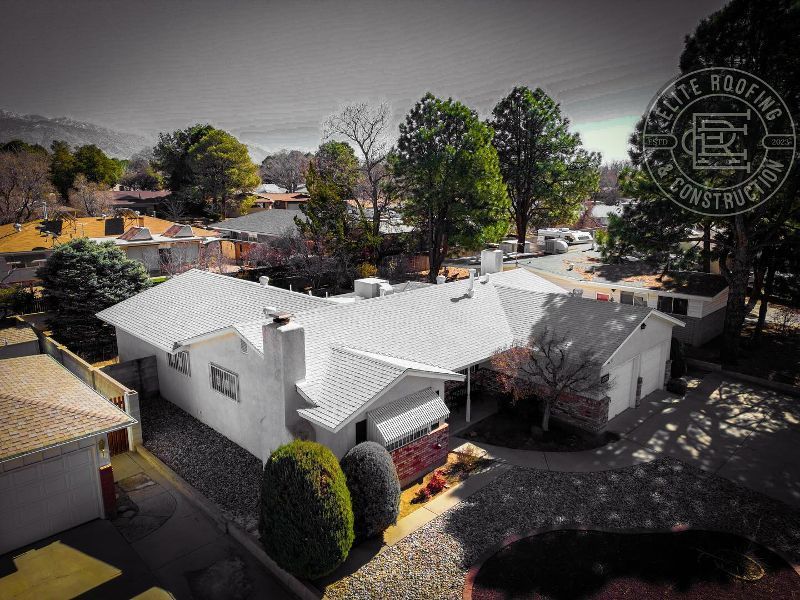 Aerial view of a white house with a new roof and a green front yard. Celtic Roofing logo in the upper right.