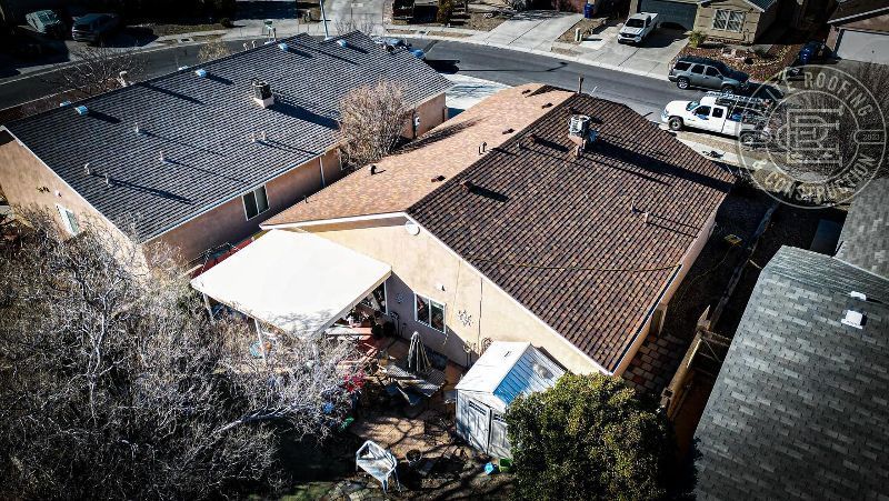 Aerial view of houses with different colored roofs in a suburban neighborhood.
