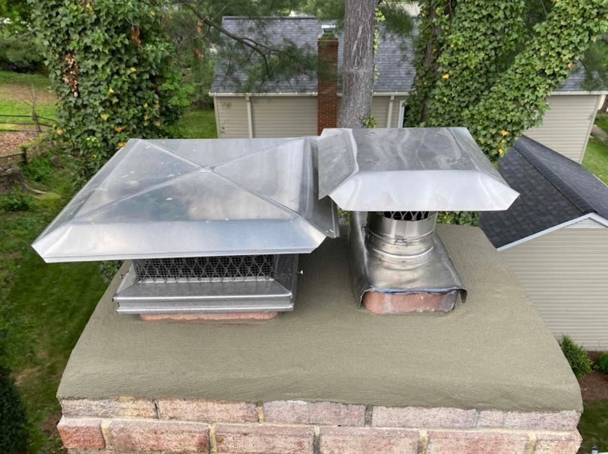 Two metal chimney caps on a brick chimney.