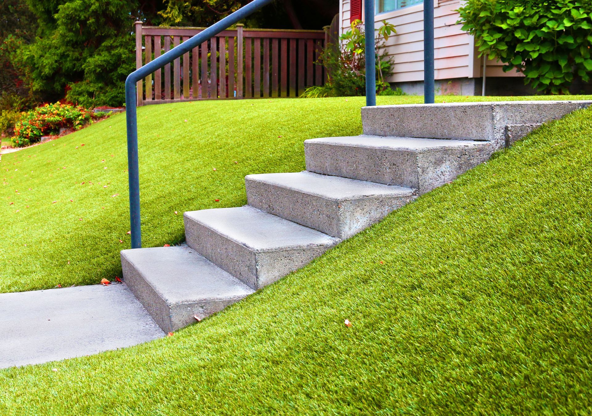 steps on a grassy hill with railing