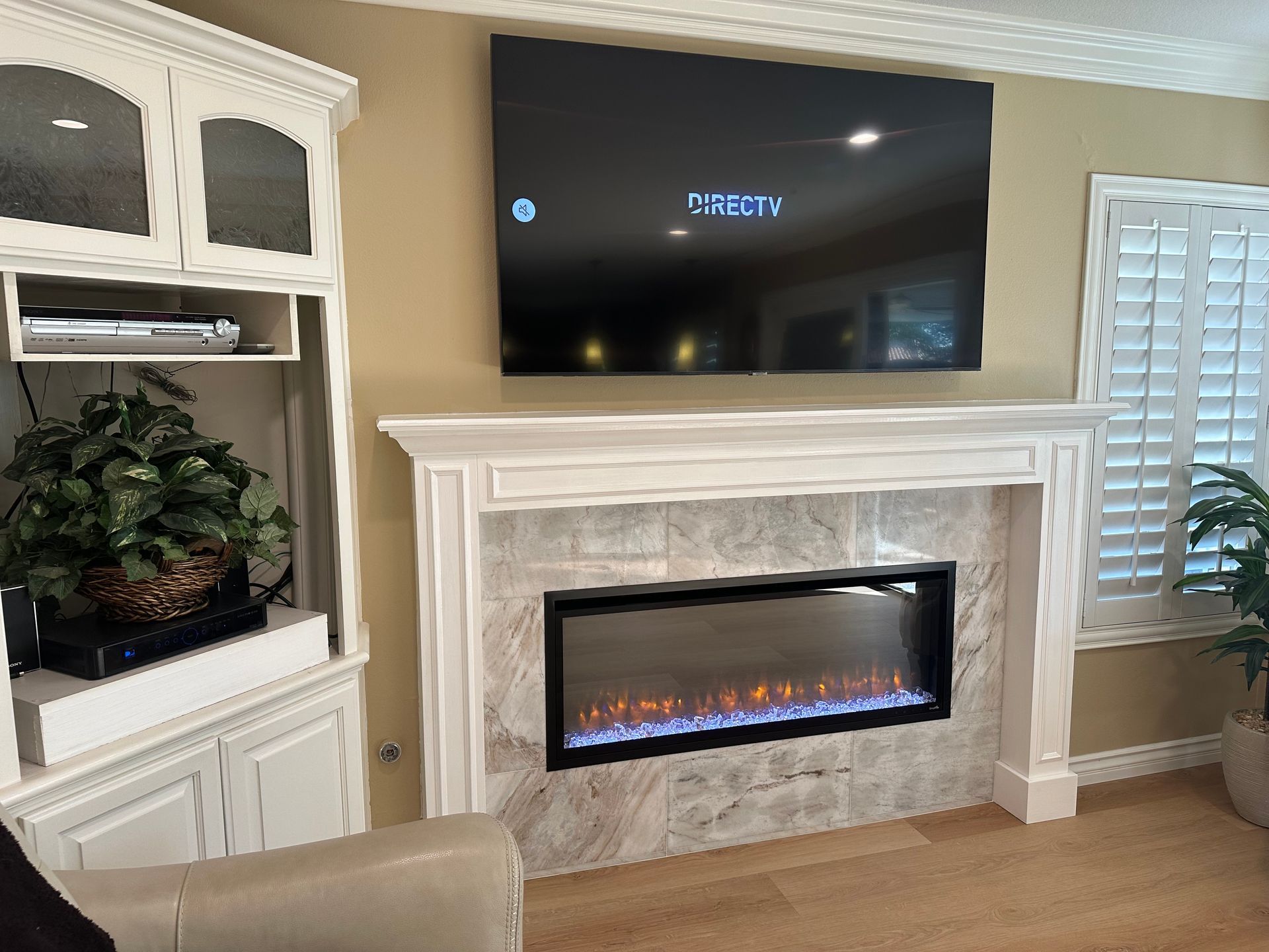 A living room with a fireplace and a flat screen TV above it.