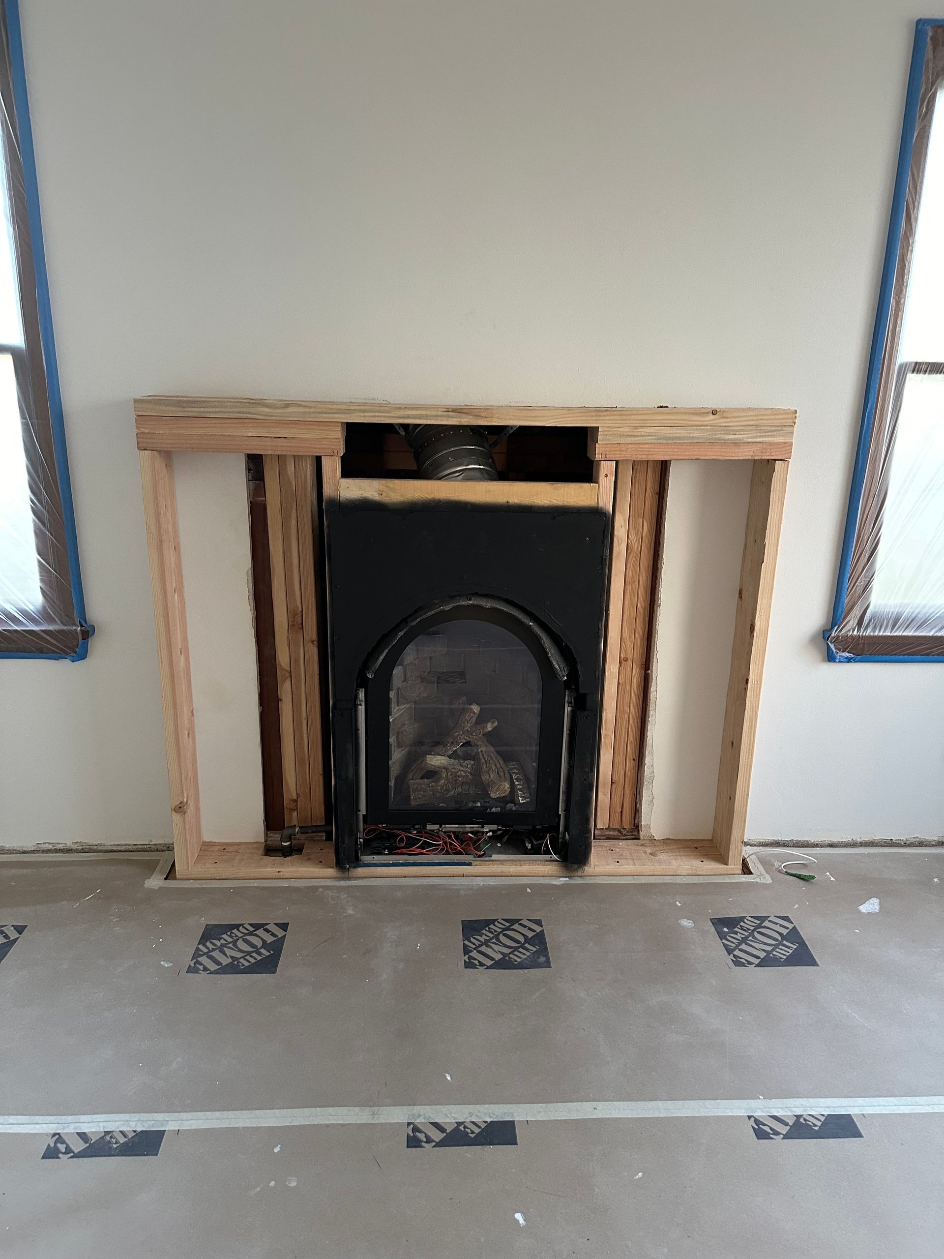 A fireplace is being built into a wall in a living room.