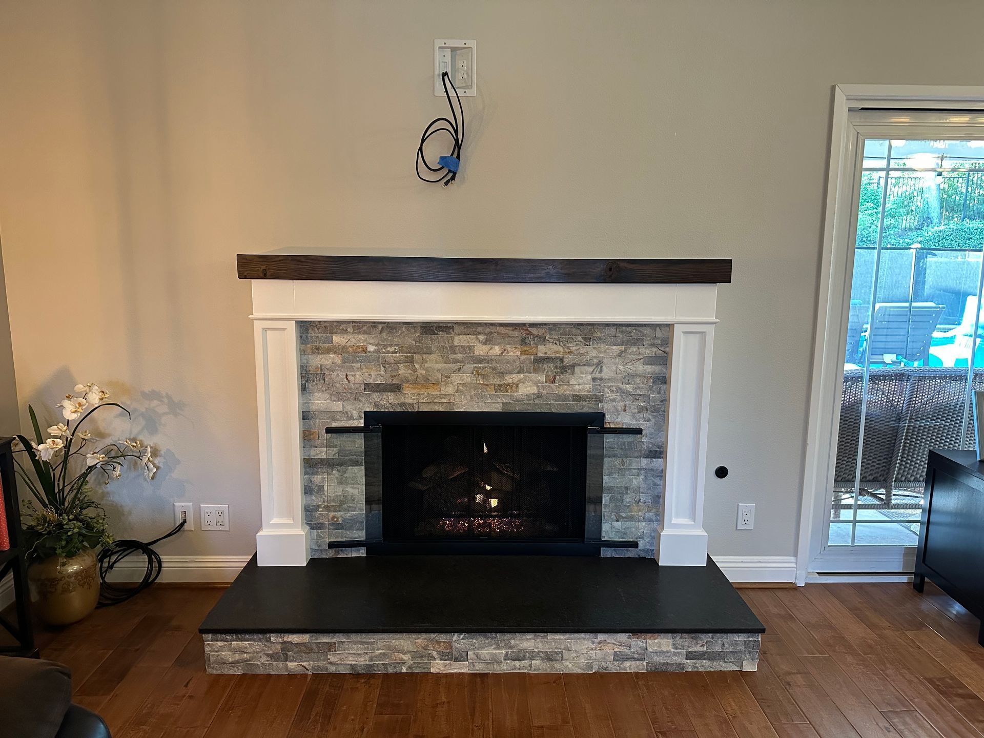 A living room with a fireplace and a sliding glass door.