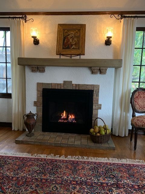 A living room with a fireplace and a rug.