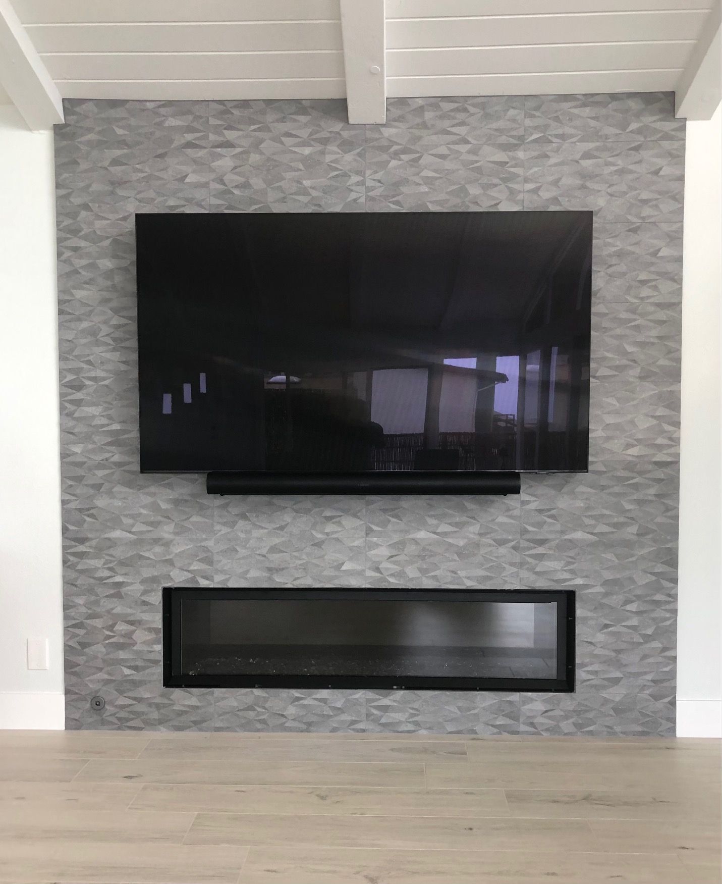 A living room with a fireplace and a flat screen TV mounted on the wall.