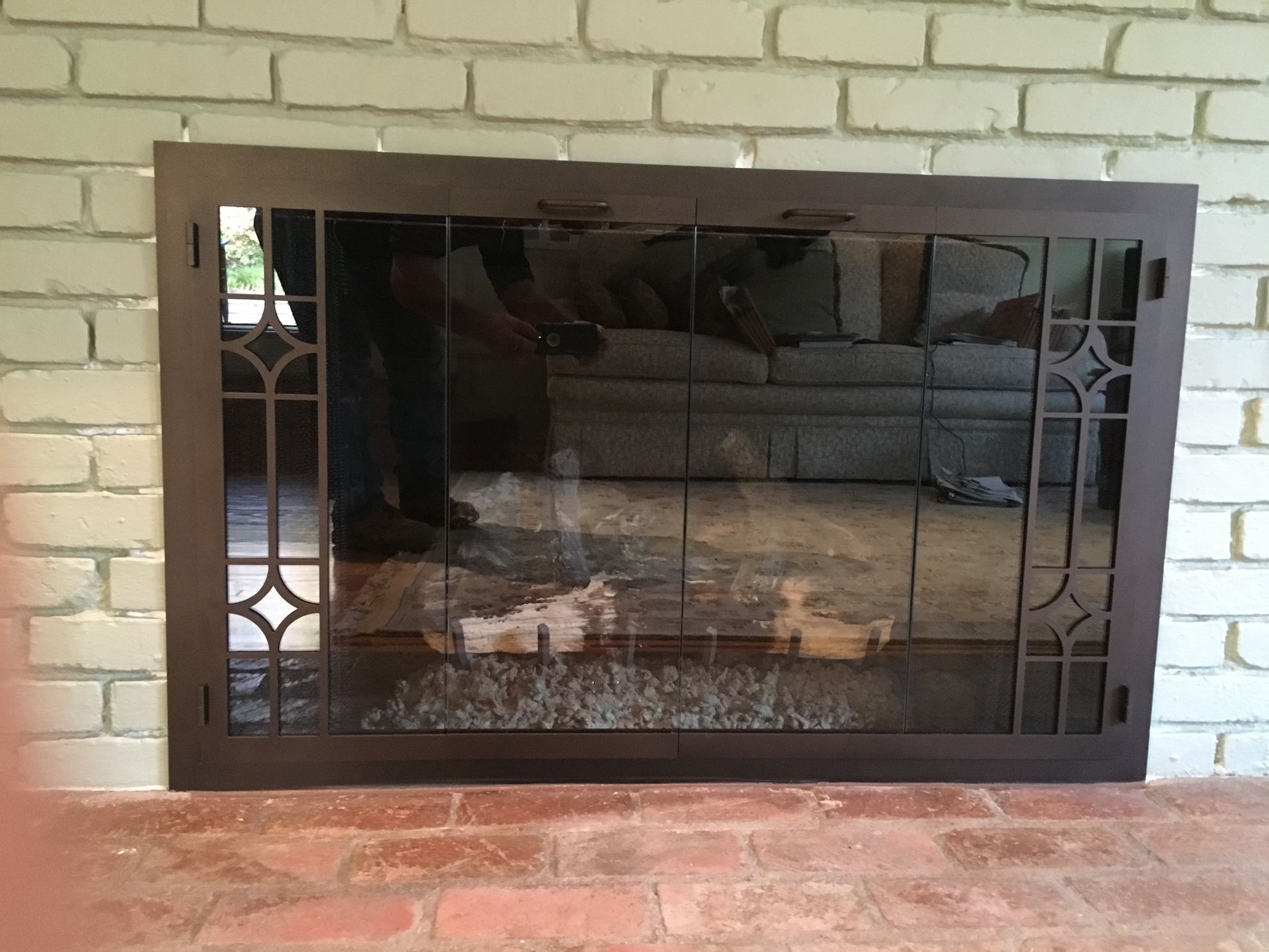 A fireplace with a stained glass screen on it.