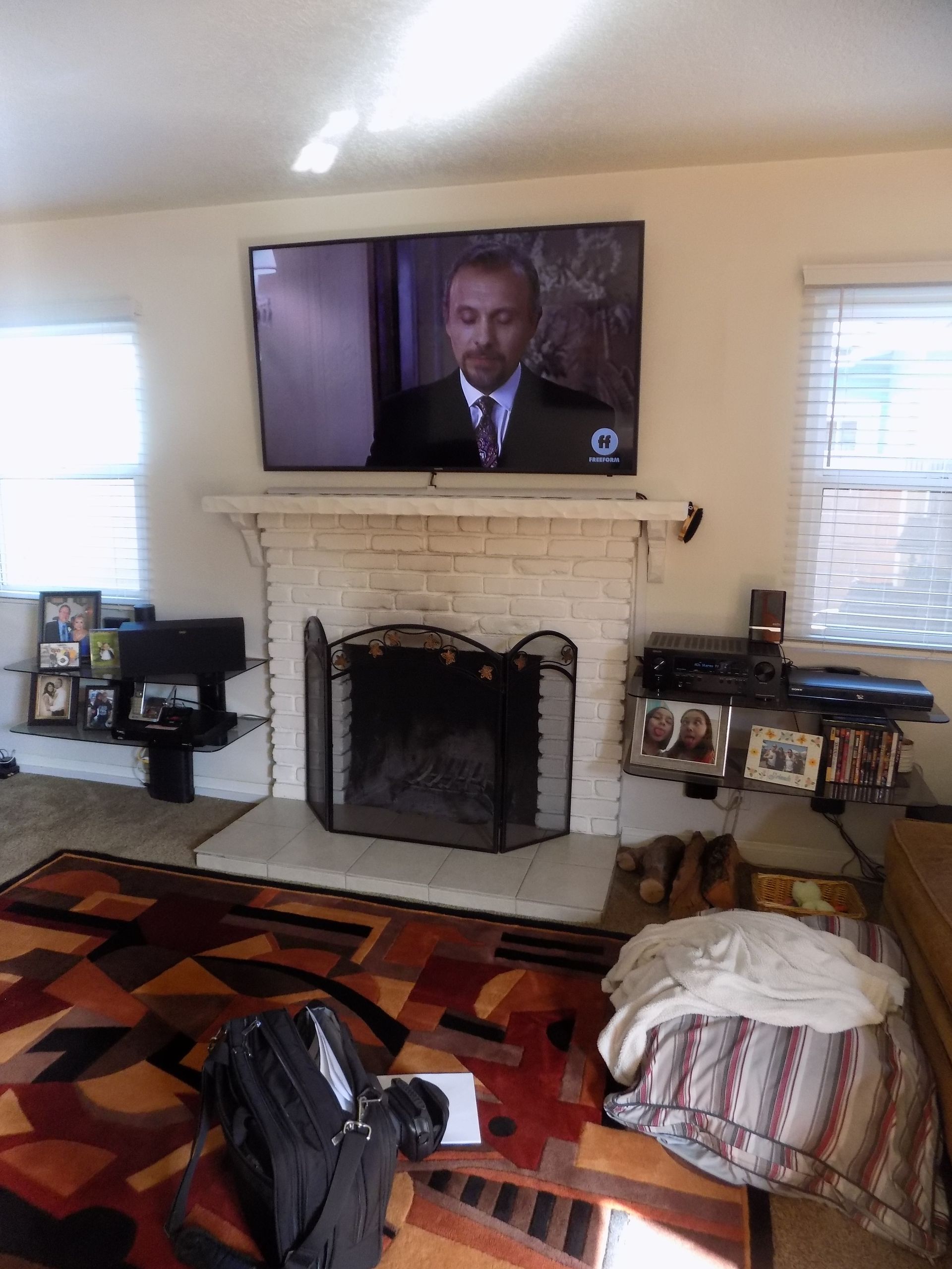 A living room with a fireplace and a flat screen TV.