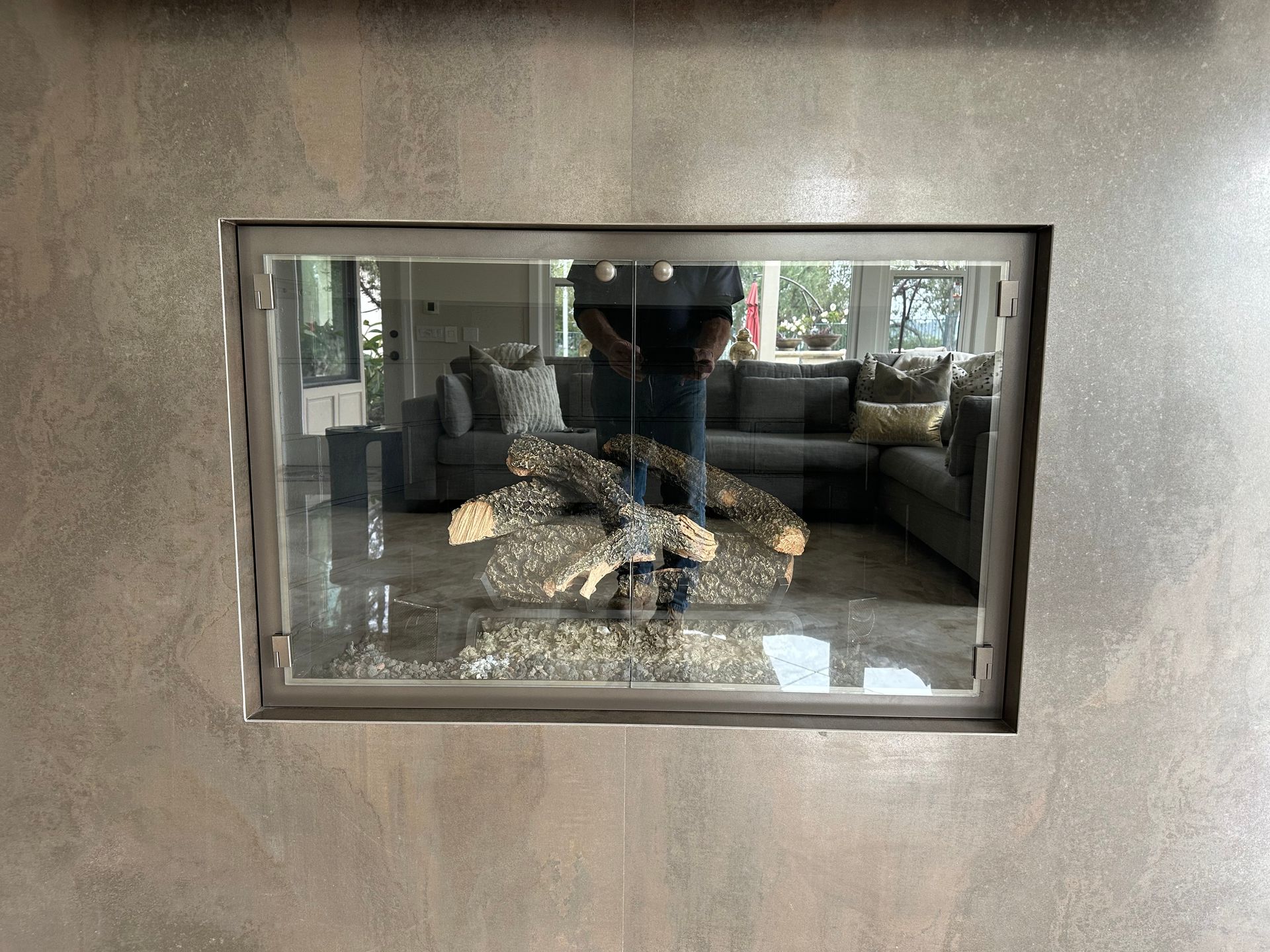 A man is standing in front of a fireplace in a living room.