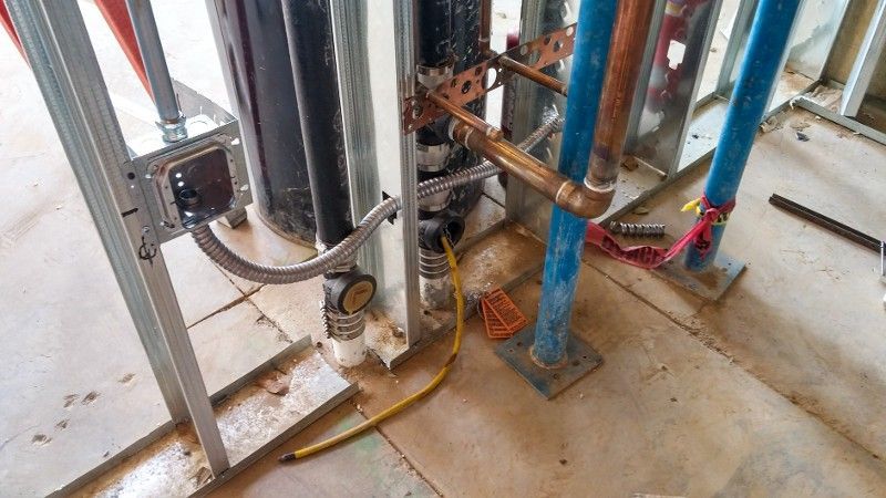 A room with a lot of pipes and wires on the floor.