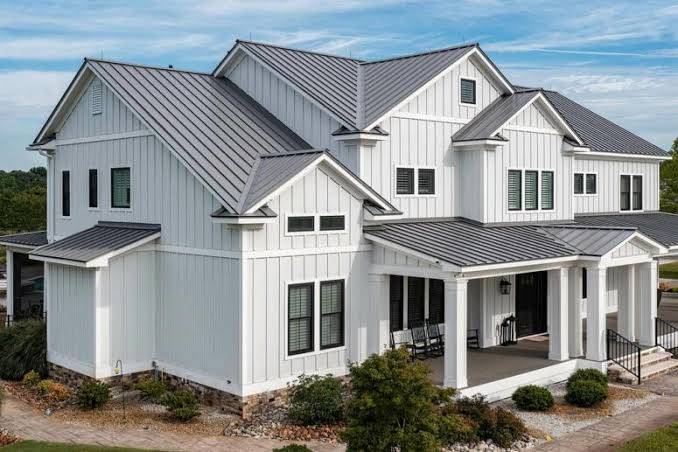 Large white two-story house with gray metal roof and covered front porch