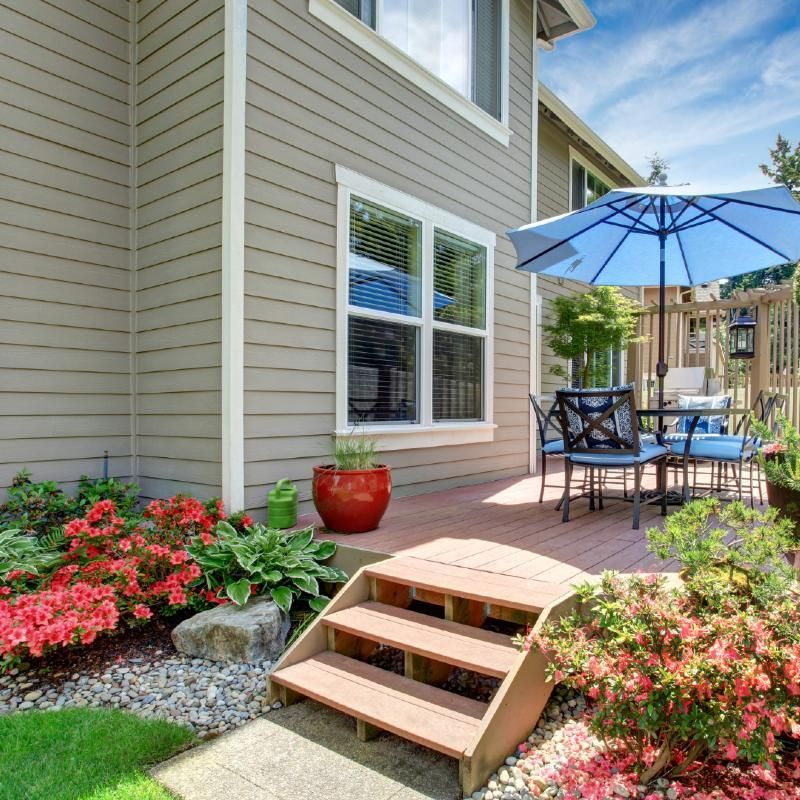 A patio with a table and chairs and a blue umbrella