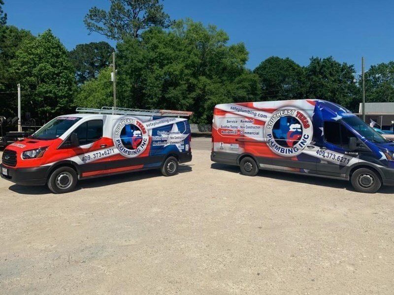 Two red white and blue vans are parked next to each other