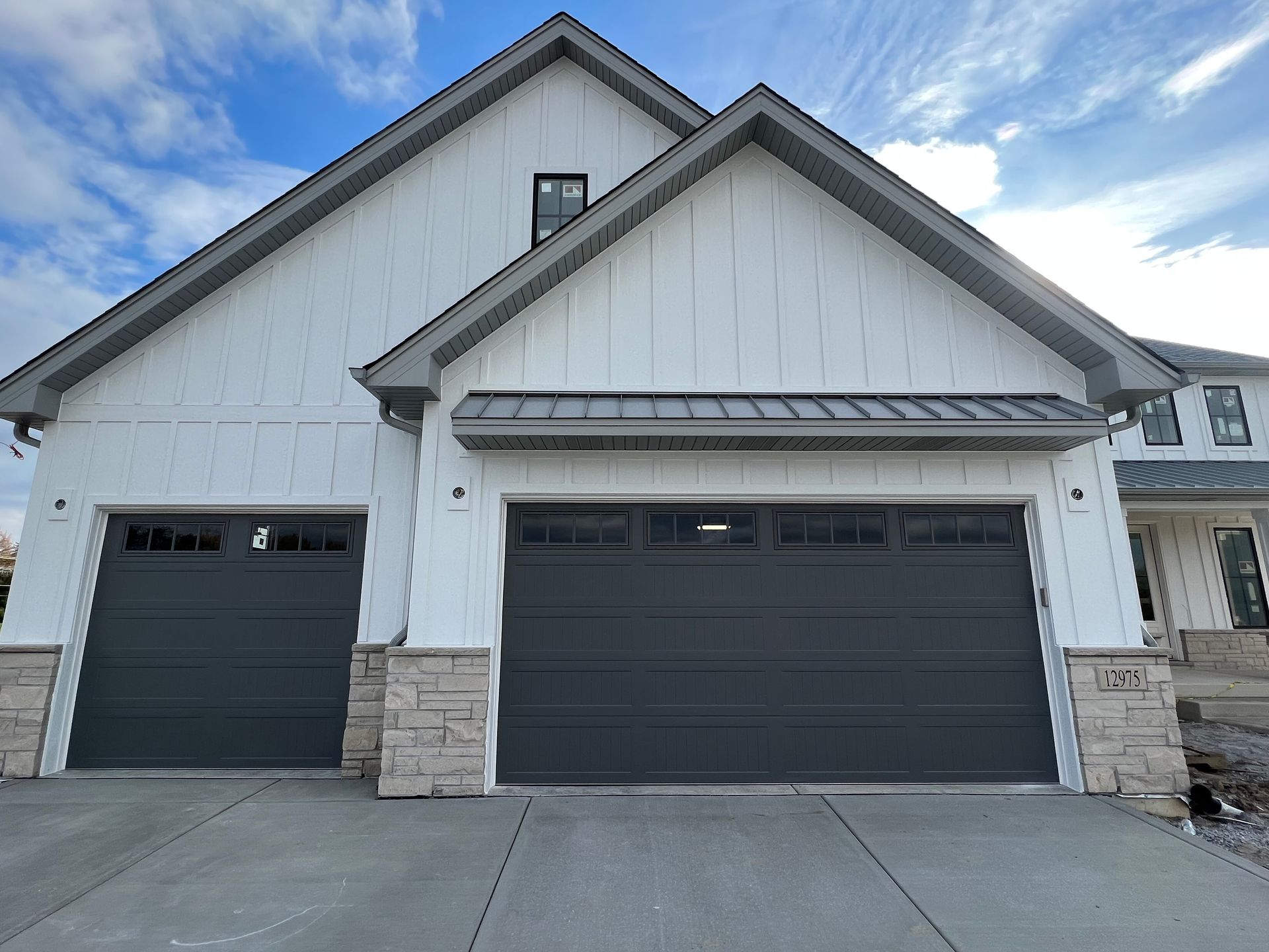 Two-car garage with dark doors and stone accents on a suburban house exterior