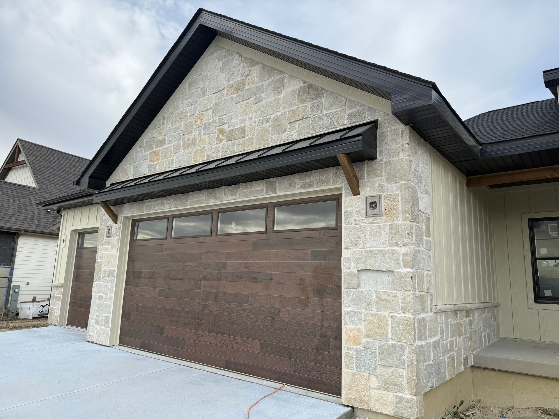 Suburban house exterior with stone facade and brown garage door