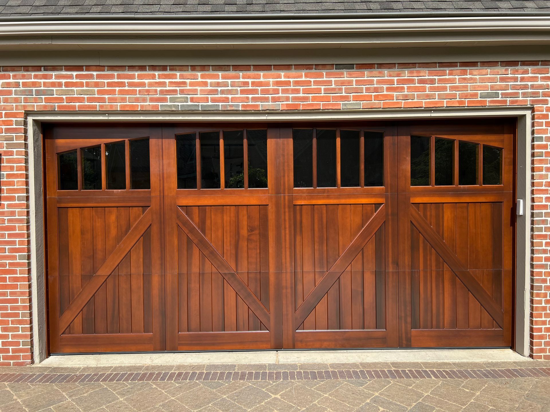 Wooden garage door with upper windows set in a red brick building