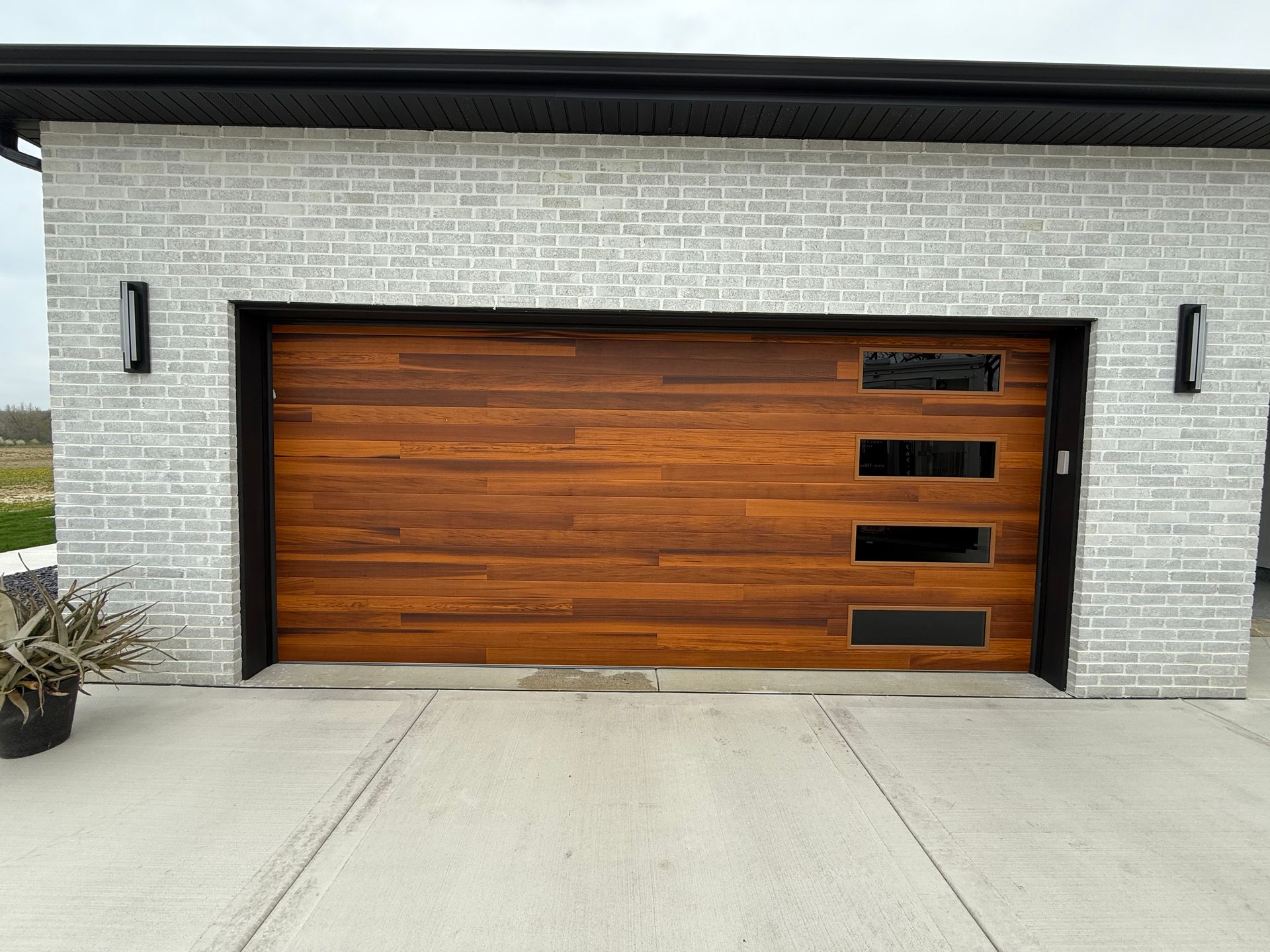 Modern house exterior with a large wooden garage door and light brick walls