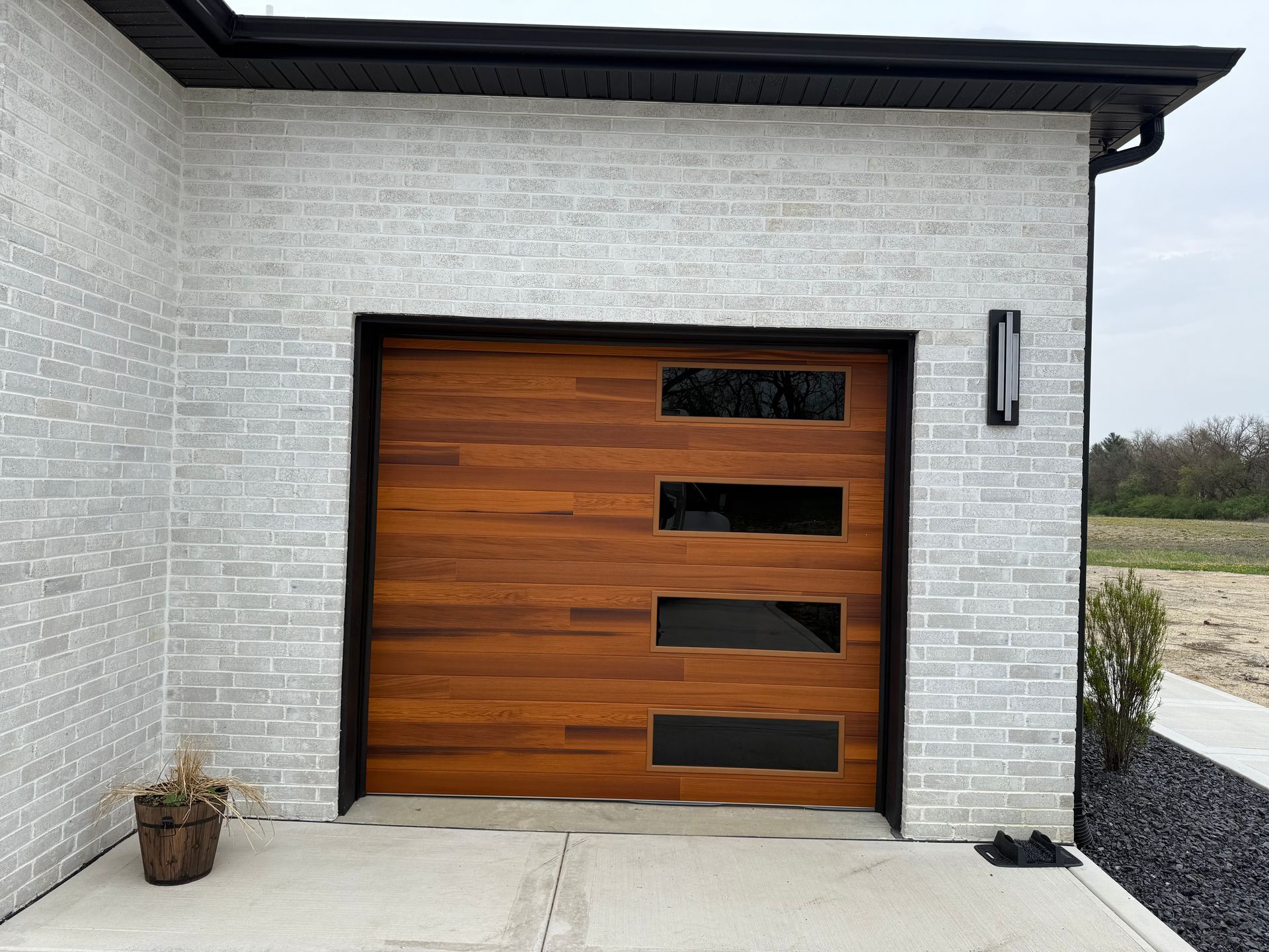 Modern house exterior with a wood garage door set in a white brick wall