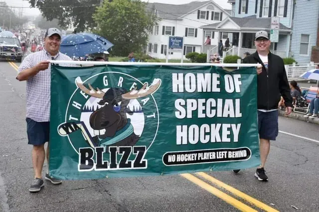 Two men carry a banner for 