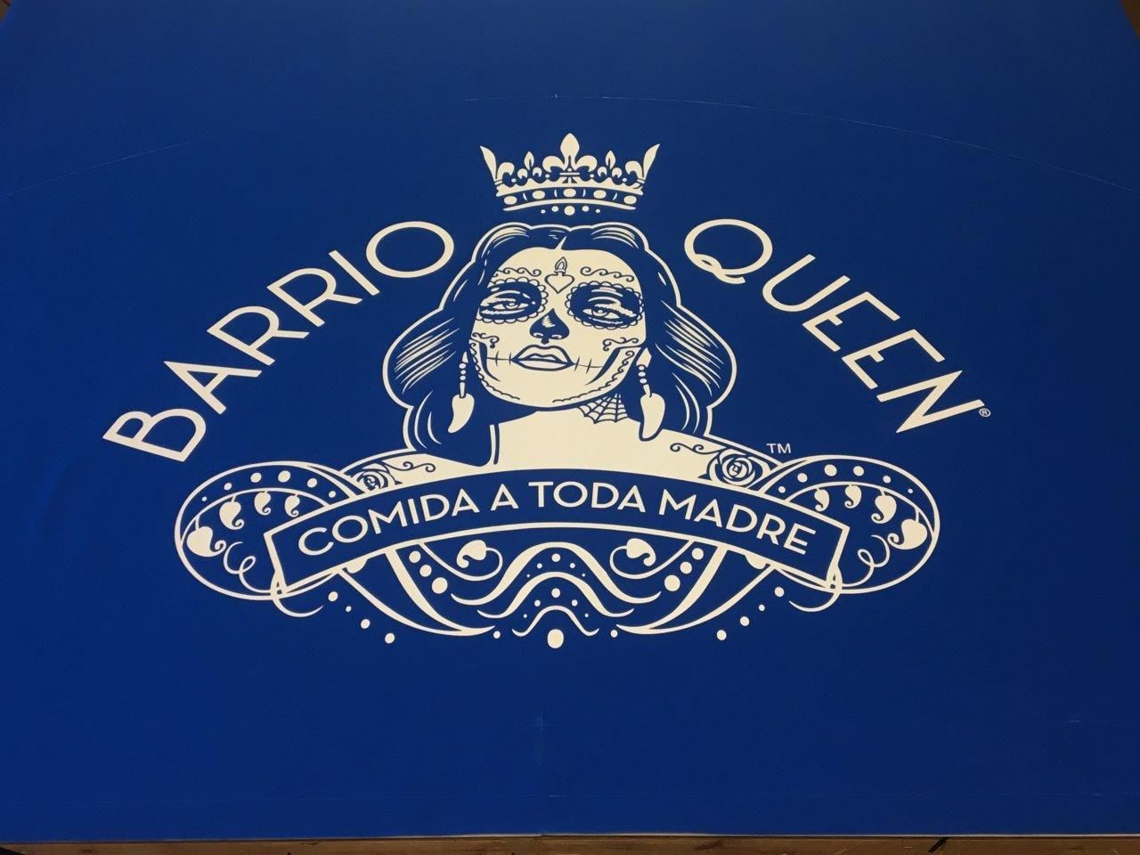 A blue sign that says barrio queen comida a toda madre
