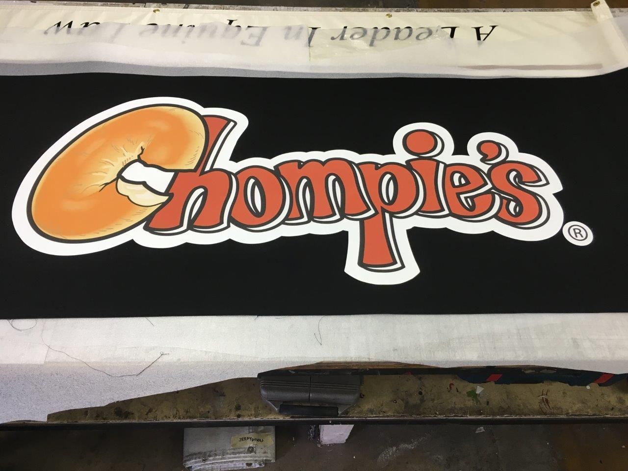A black sign that says chompies on it