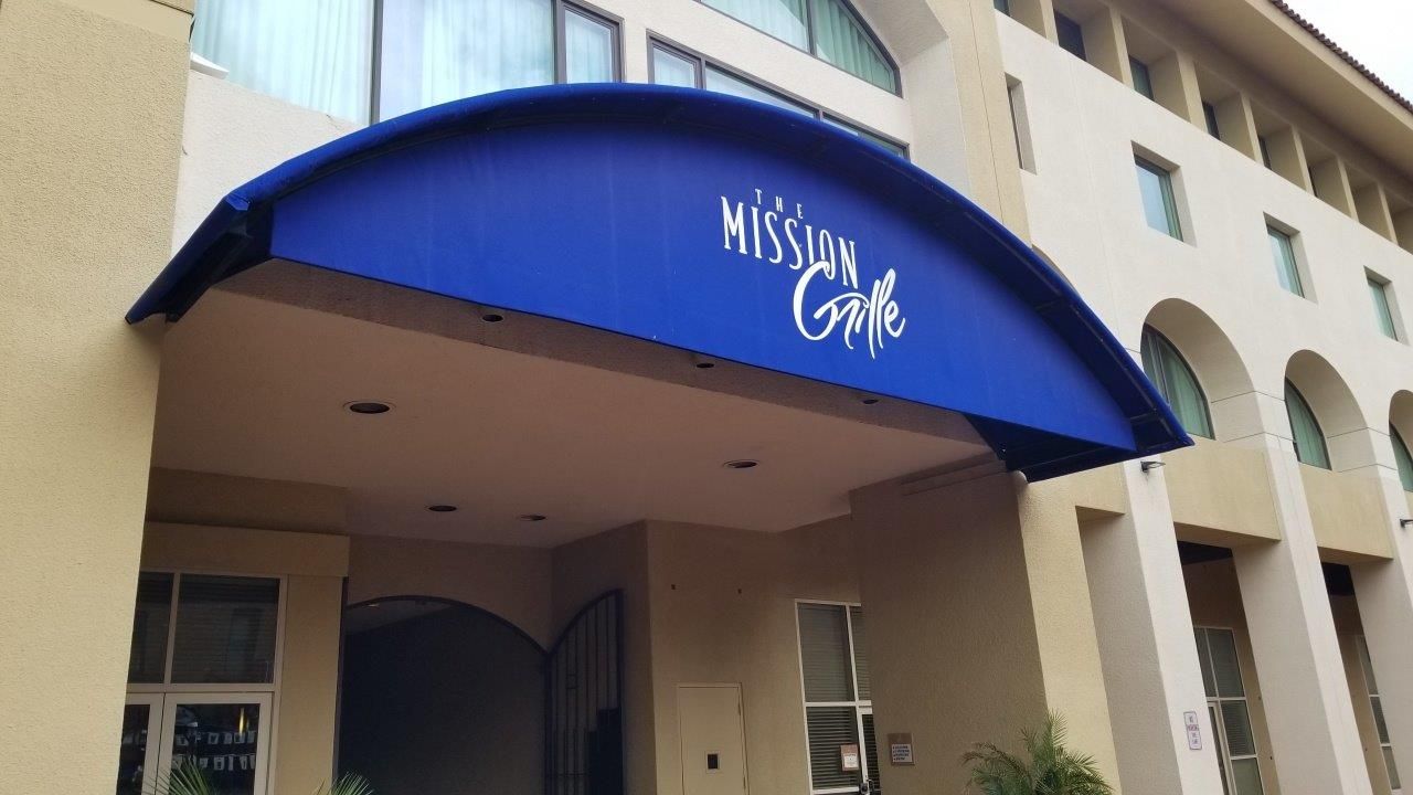 A building with a blue awning that says mission gate