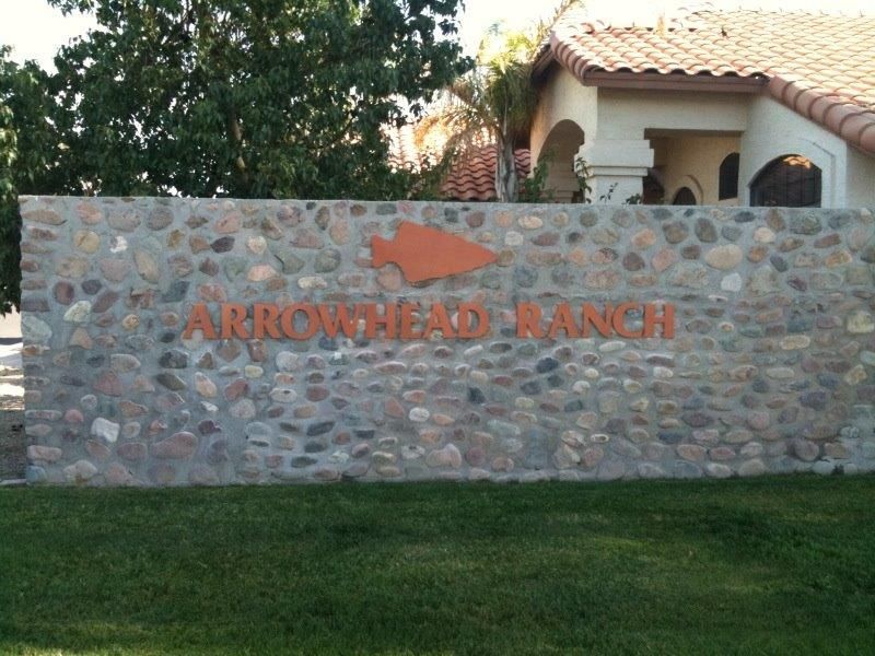 A stone wall with arrowhead ranch written on it