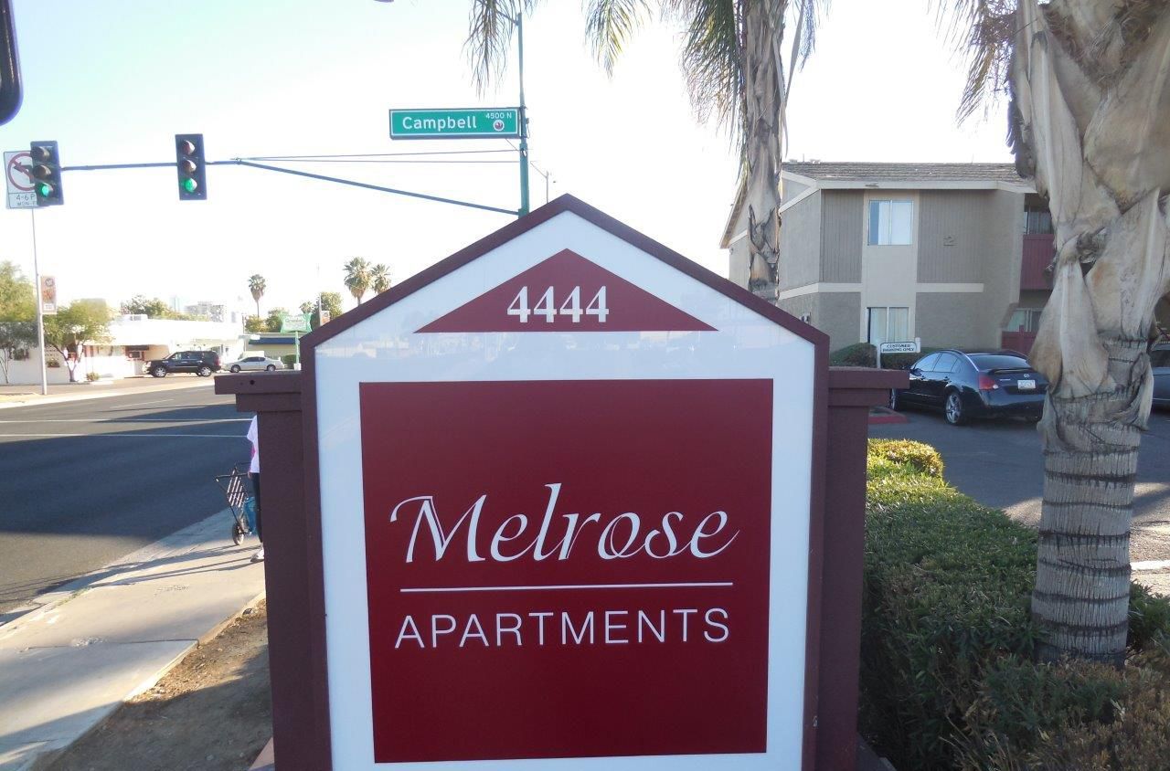 A red and white sign for melrose apartments