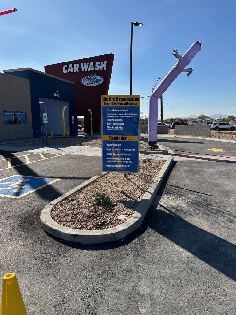 A car wash with a sign in front of it.