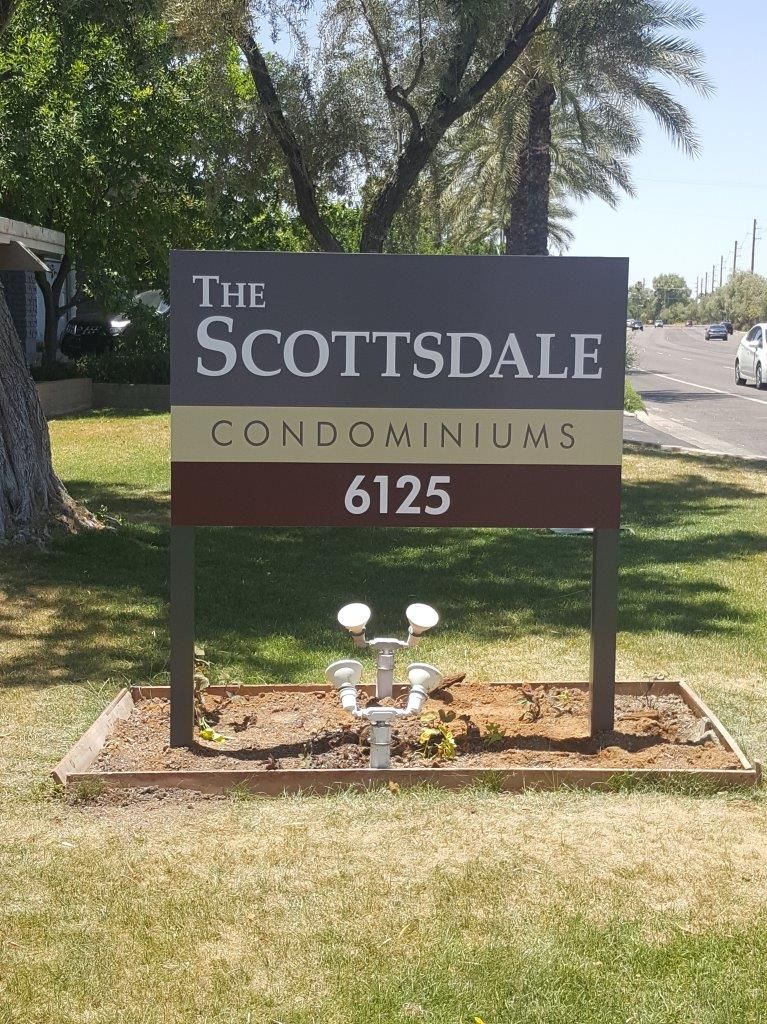 A sign for the scottsdale condominiums sits in the grass