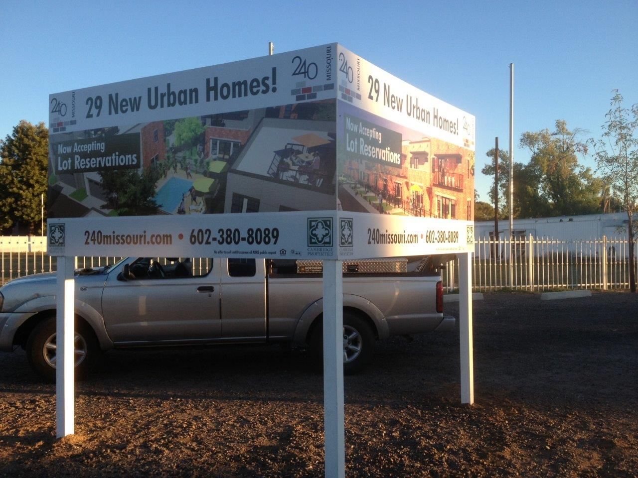 A truck is parked in front of a sign that says 29 new urban homes