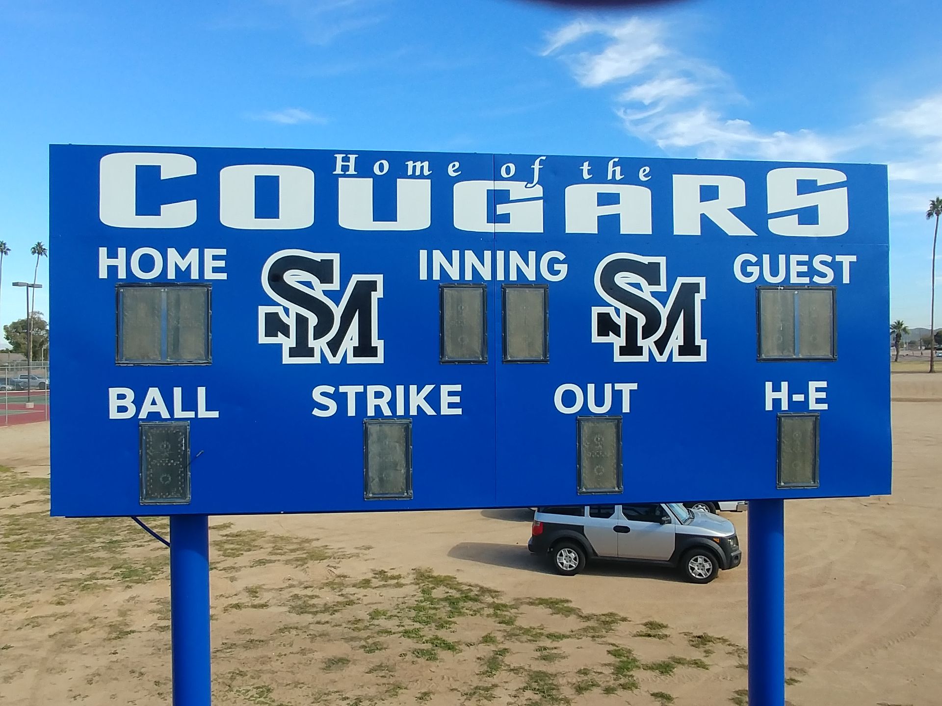 A blue sign that says home of the cougars