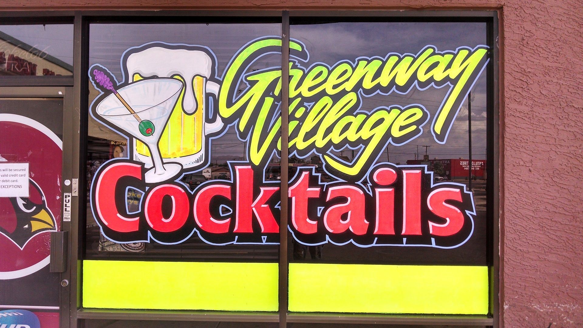A window with a sign that says greenway village cocktails