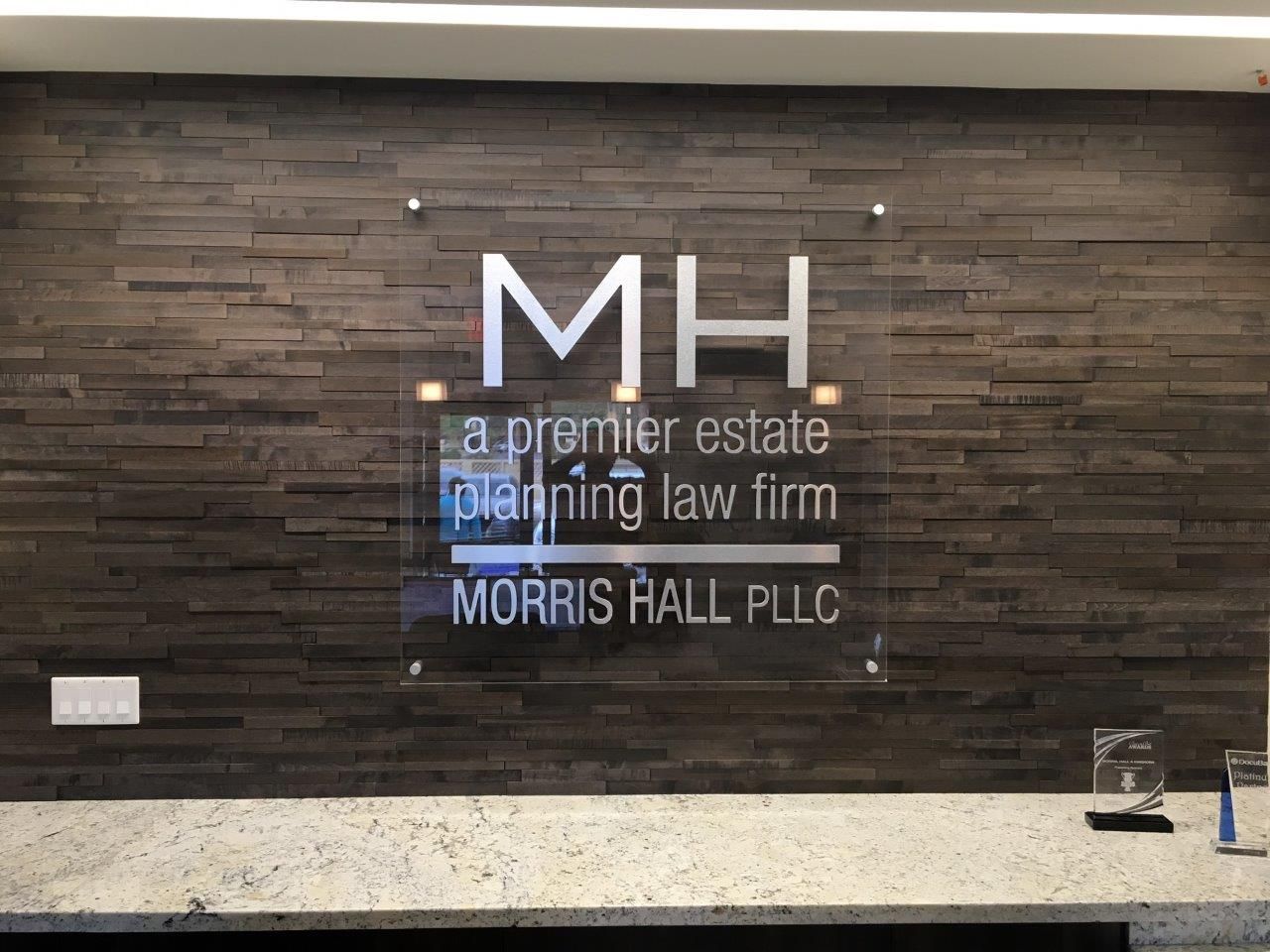 A sign on a wall that says mh a premier estate planning law firm morris hall pllc.