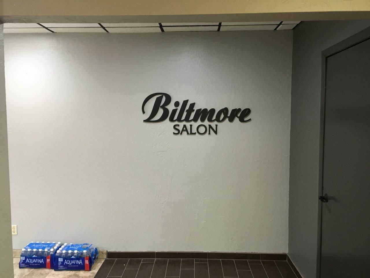 A sign on a wall that says billmore salon
