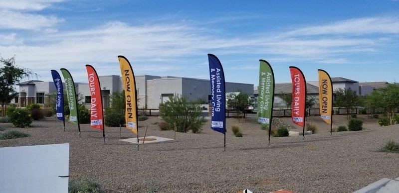 A row of flags are lined up in a circle in front of a building.
