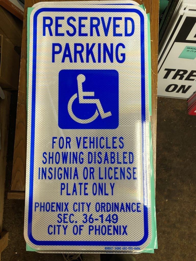 A reserved parking sign for vehicles showing disabled insignia or license plate only