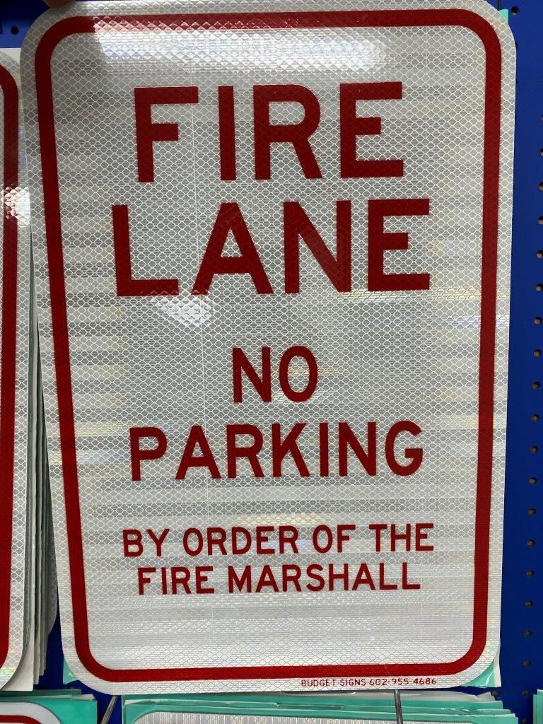 A fire lane no parking sign is on a shelf.