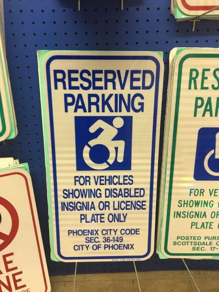 A sign that says reserved parking for vehicles showing disabled insignia or license plate only