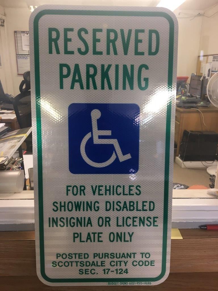 A reserved parking sign for vehicles showing disabled insignia or license plate only