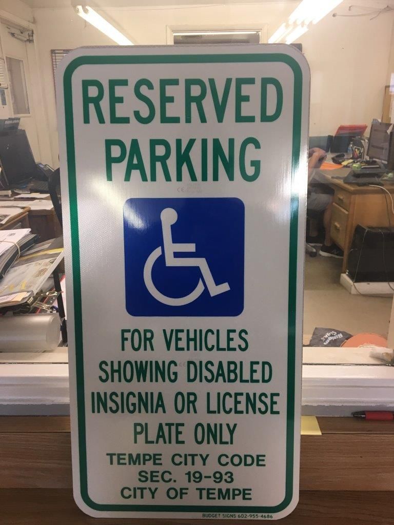 A reserved parking sign for vehicles showing disabled insignia or license plate only